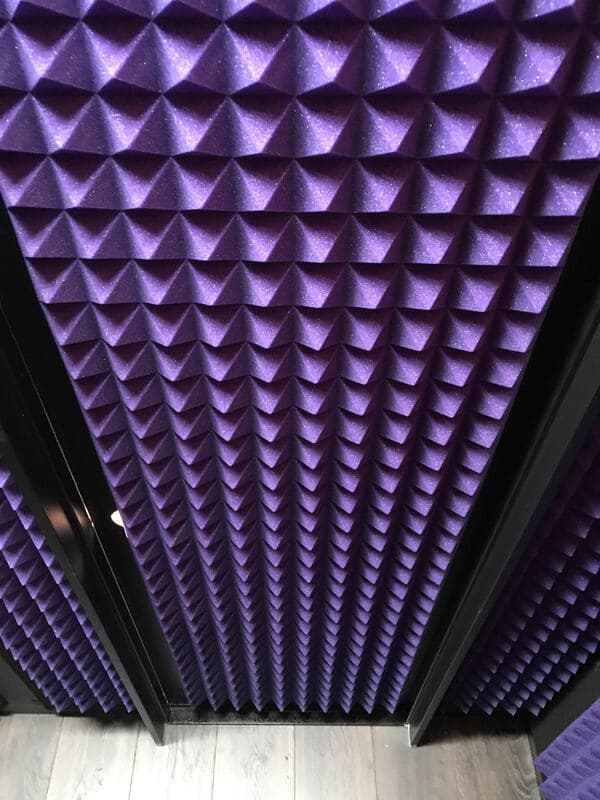 Purple soundproofing tiles with a pyramid pattern in a studio setting. Acoustic wall design.